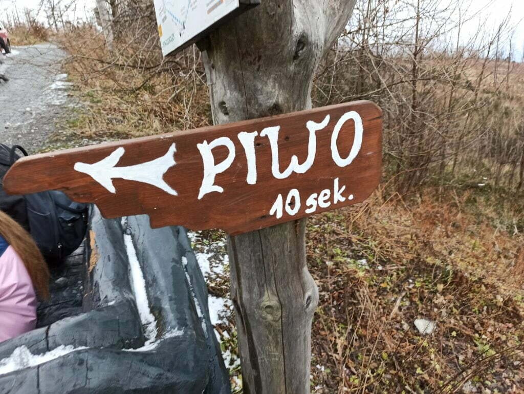 Przybity do drzewa drogowskaz z napisem "piwo 10 sek." i strzałką.