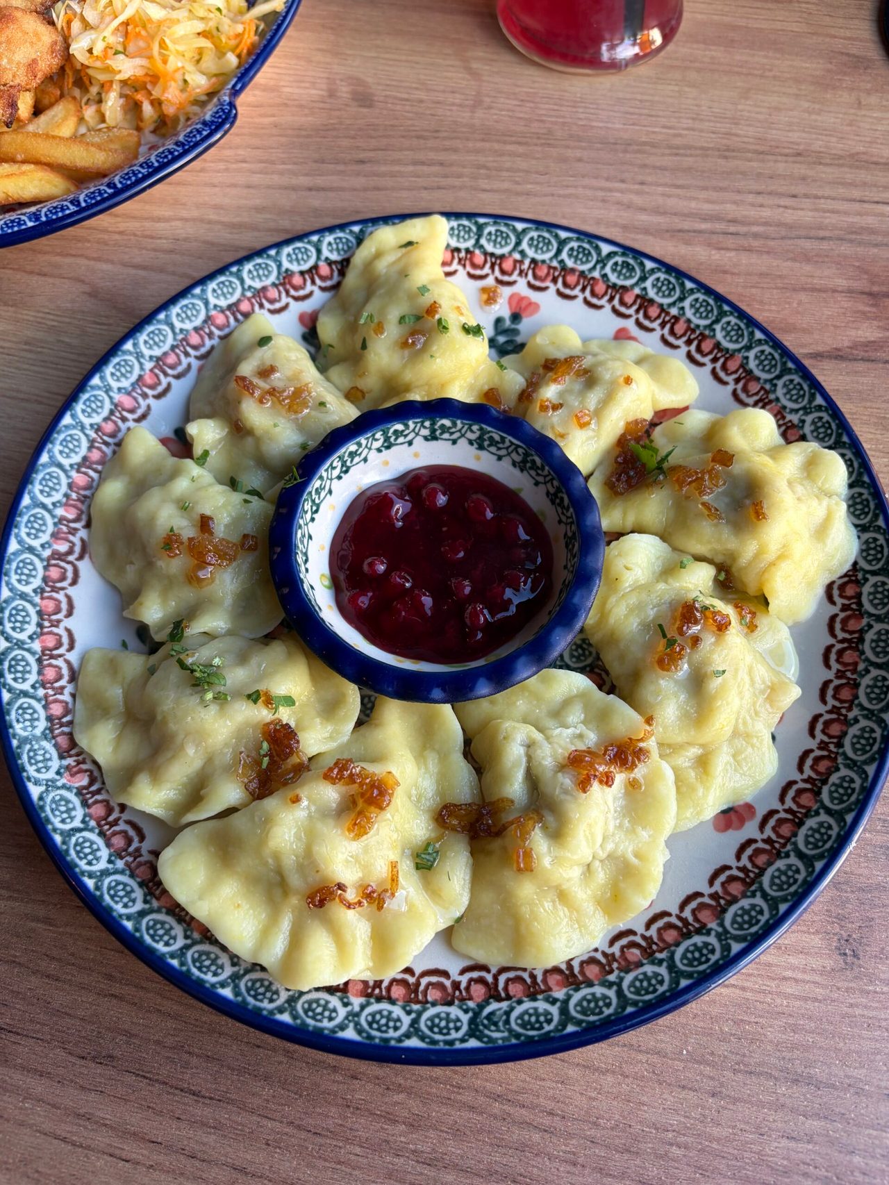 Pierogi i sos żurawinowy na zdobionym talerzu