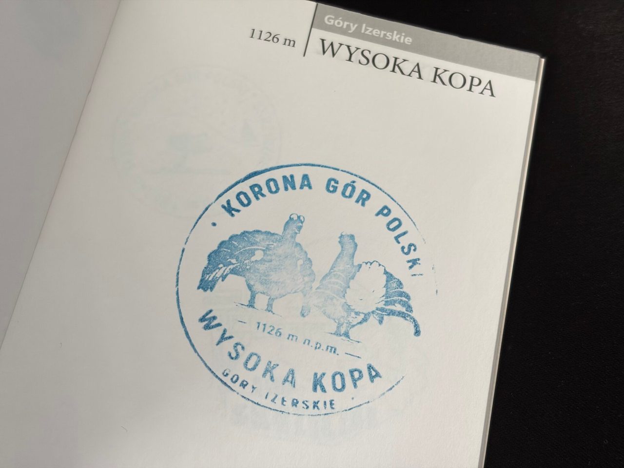 Pieczątka Korony Gór Polski z cietrzewiem przybita w książeczce