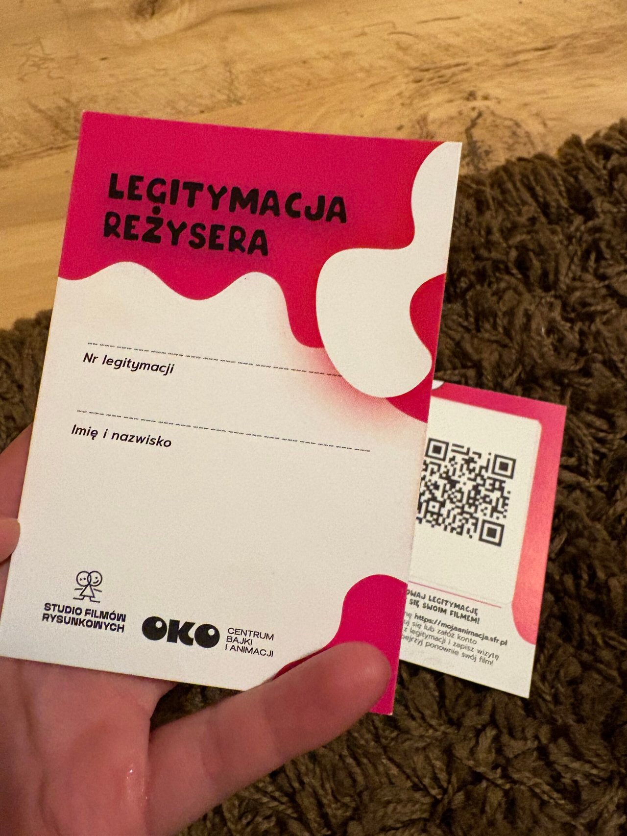 Legitymacja reżysera z Centrum OKO trzymana w dłoni