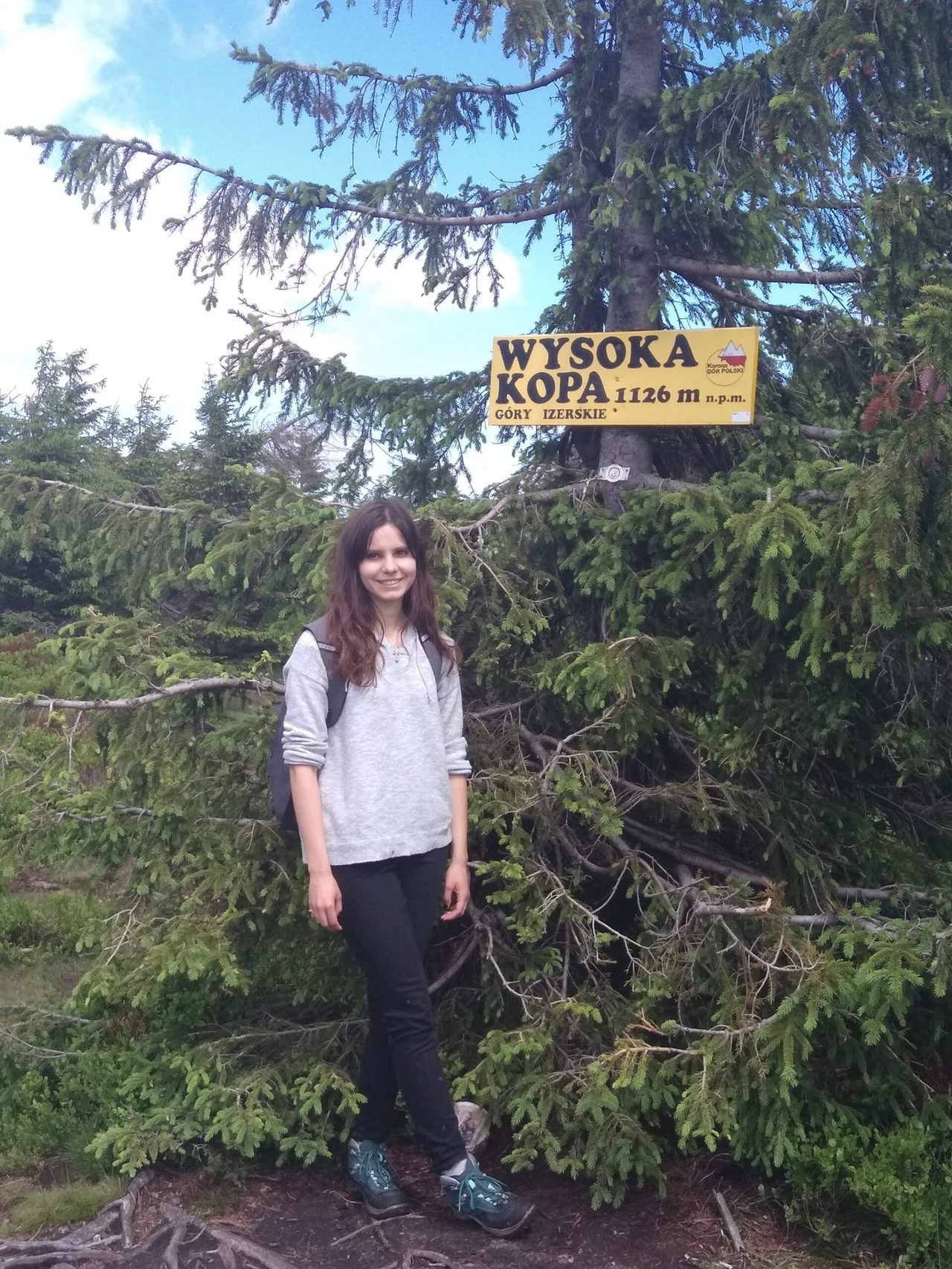 Dziewczyna na szczycie Wysokiej Kopy pod tabliczką szczytową